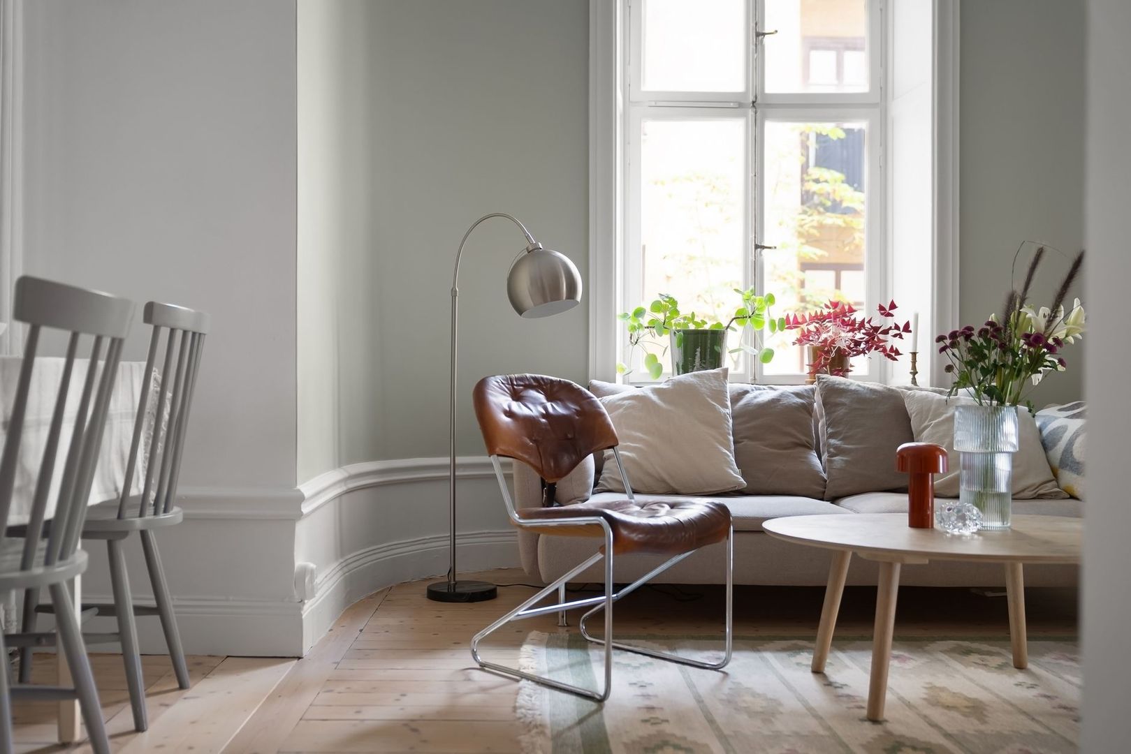 Ljust vardagsrum med golvlampa, fönster och flera ljuskällor